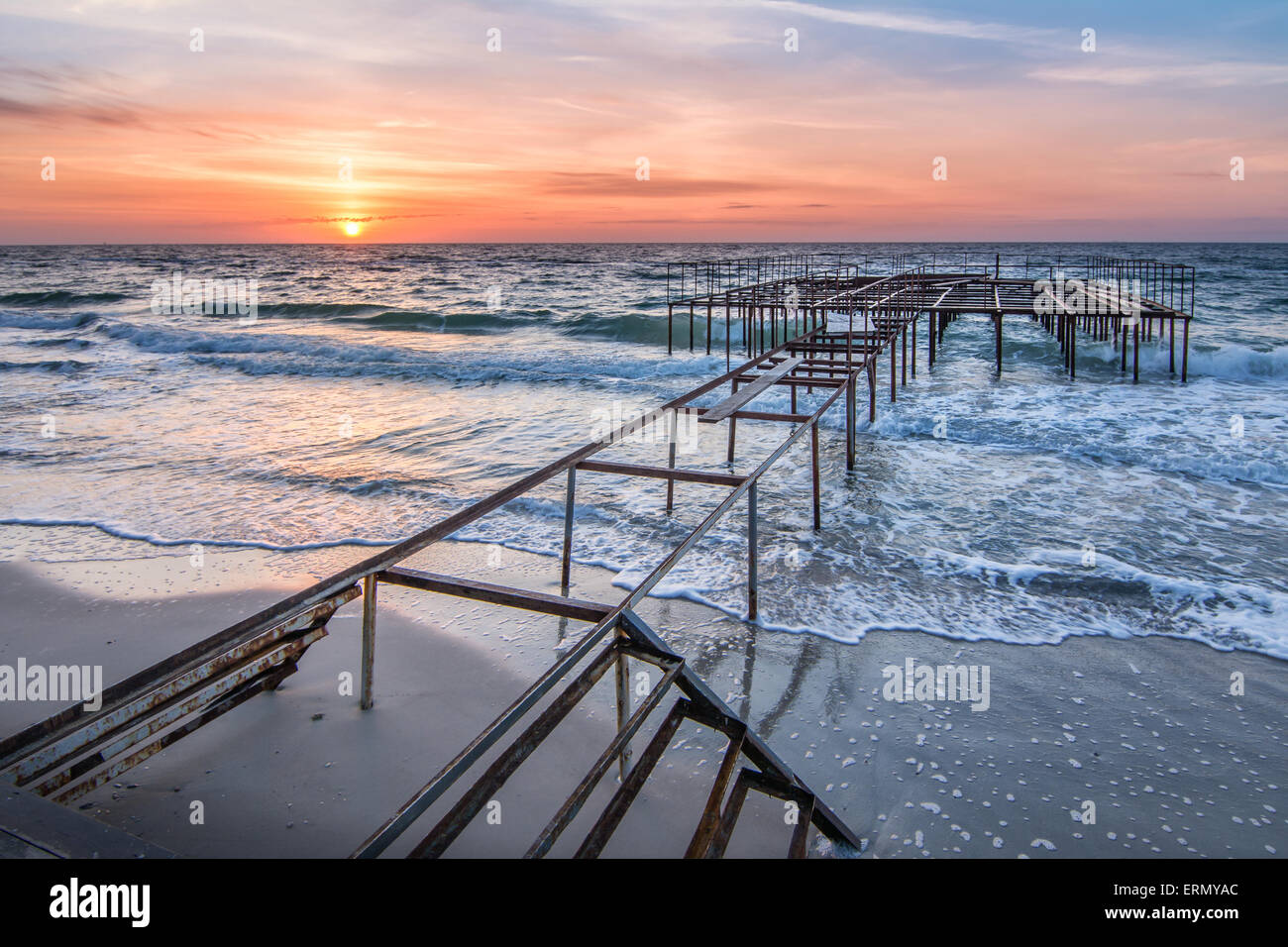 Sunrise on old ocean pier - sea waves unusual background Stock Photo ...