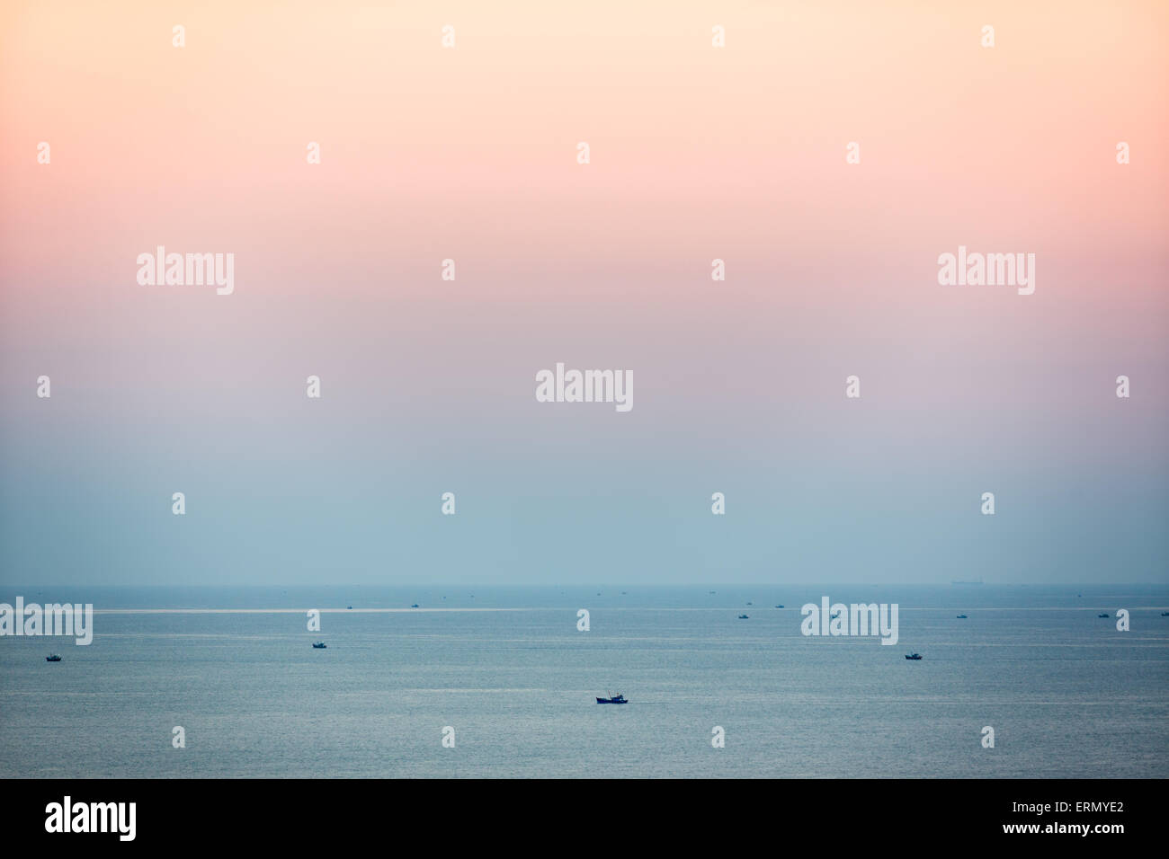 Small fishing boats in South China Sea at dusk, Mui Ne, Vietnam Stock Photo