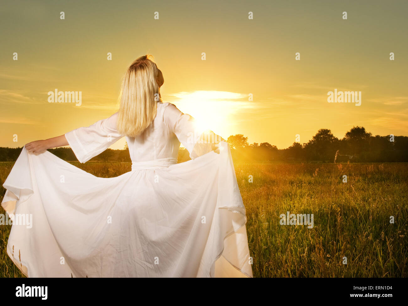 Beautiful woman with in the field at sunset Stock Photo - Alamy