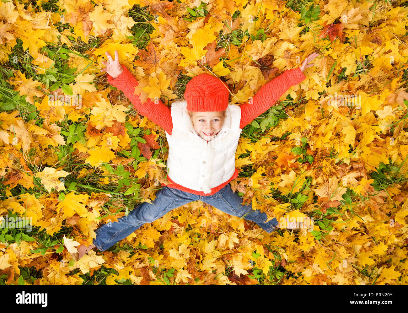 Cute little girl lying in autumn leaves Stock Photo - Alamy