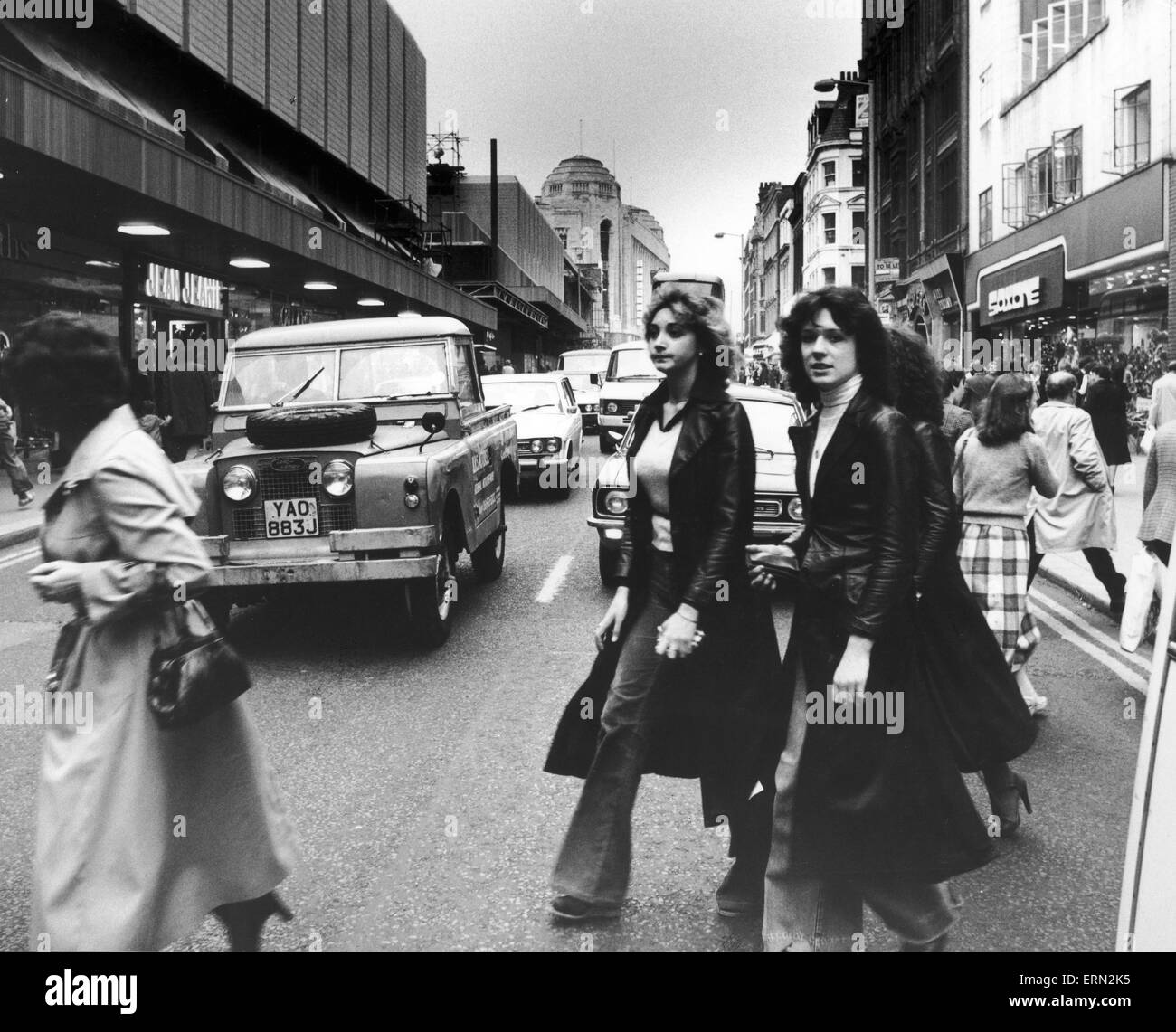Shoppers out on a Saturday afternoon dodge the traffic in Manchester City Centre. 25th October 1978 Stock Photo