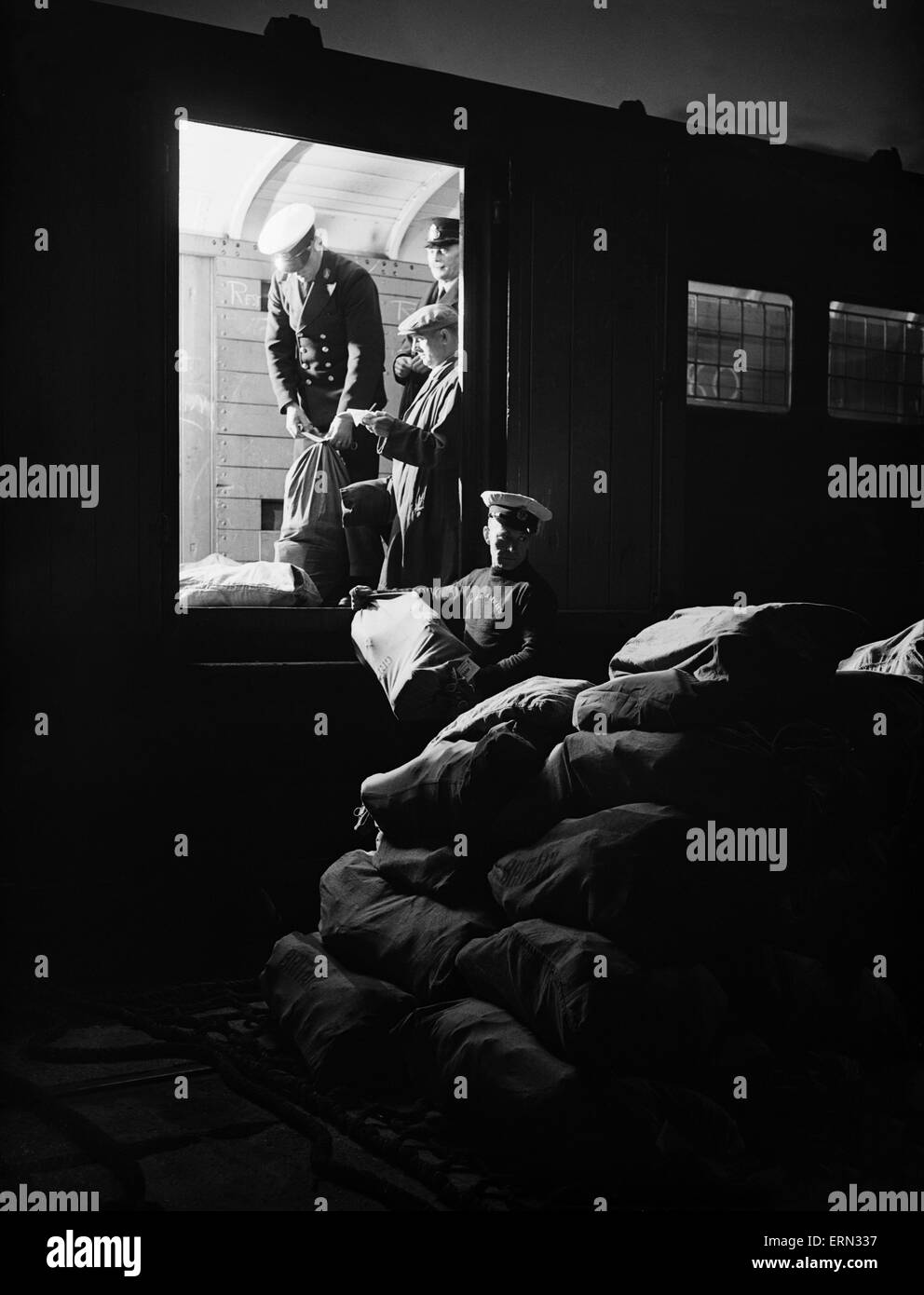 Series of images for Daily Herald Feature flight to Australia. 26th June 1938 Imperial Airways staff off load mail bags bound for Australia from the night train Stock Photo