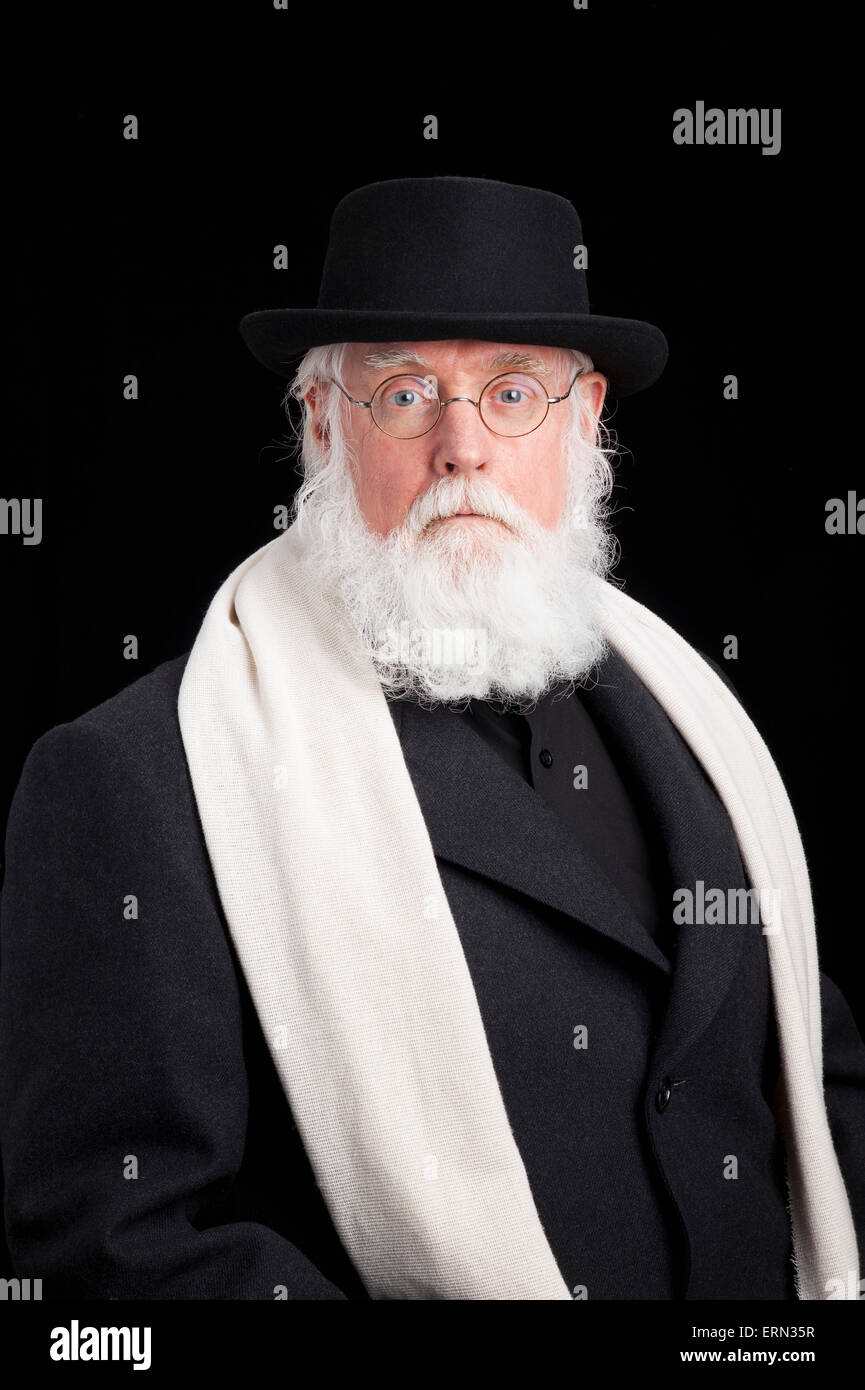 Mature bearded Jewish man wearing spectacles, hat, overcoat and a scarf; Alberta, Canada Stock Photo