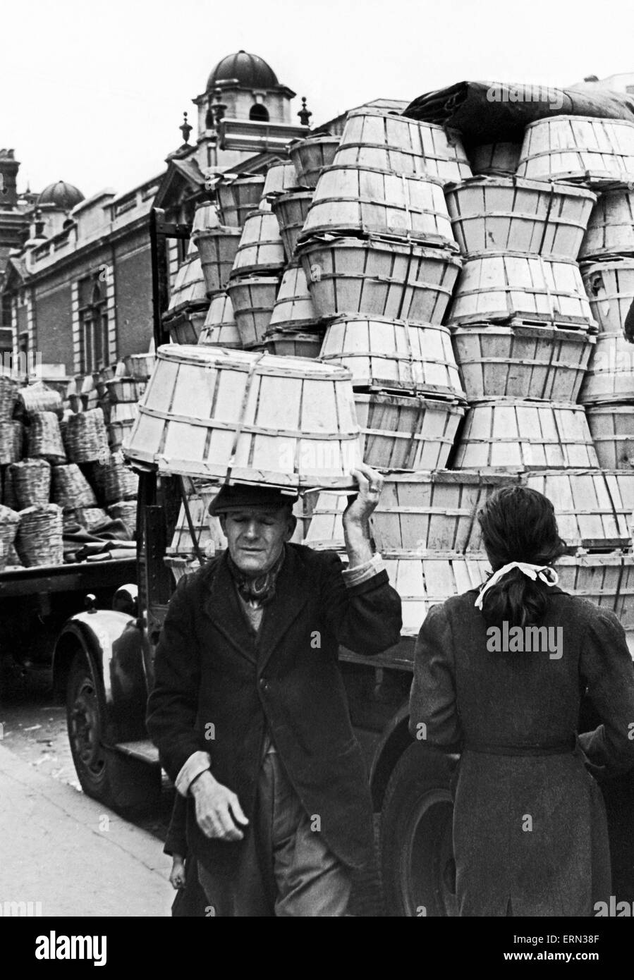 Covent Garden Market, Elderly man carried baskets on his head through the market streets. Circa 1955. Stock Photo