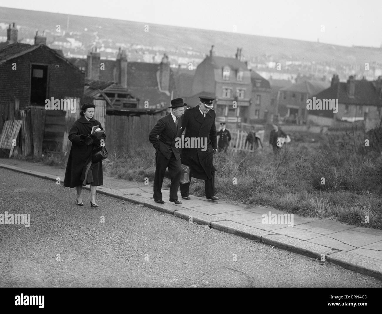Dr Keith Simpson in deep conversation with the police officer leading the investigation into the murder of Edna Chesterton, at scrub land along James Street, Chatham. The woman accompanying them is Dr Simpson secretary Jean Scott Dunn. 30th November 1951 Stock Photo