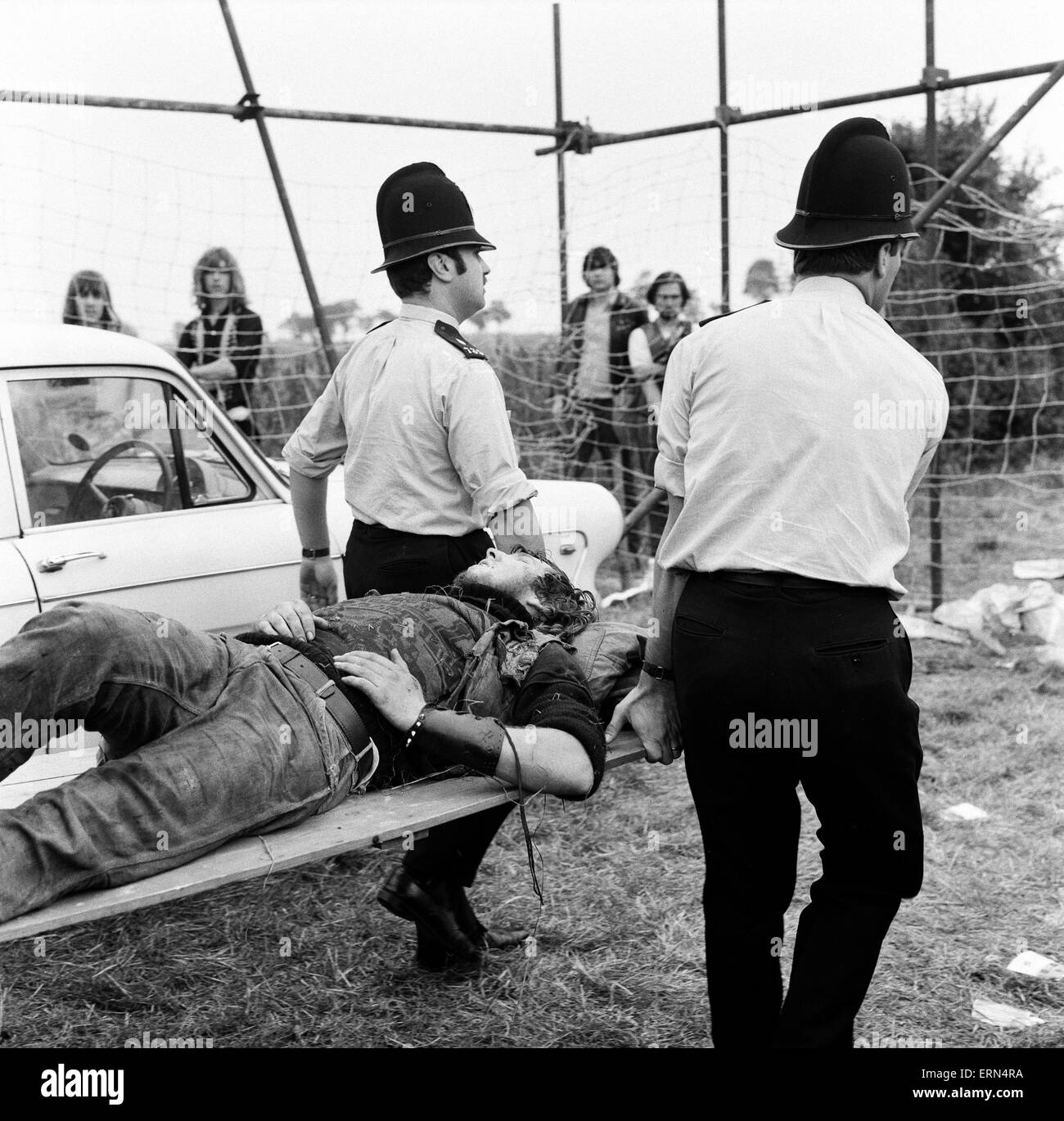 Scene at POP Festival, Weeley, Essex, following a battle between security men and Hells Angels, a young injured Hells Angel is carried away on a stretcher by police, 28th August 1971. Stock Photo