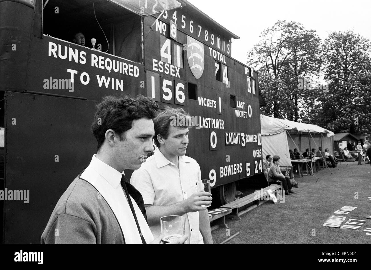 For the first time County cricket was played on a Sunday. The match between Essex and Somerset took place at Valentine's Park in Ilford. Two beer drinking cricket fans watch in front of the scorebord. 15th May 1966. Stock Photo