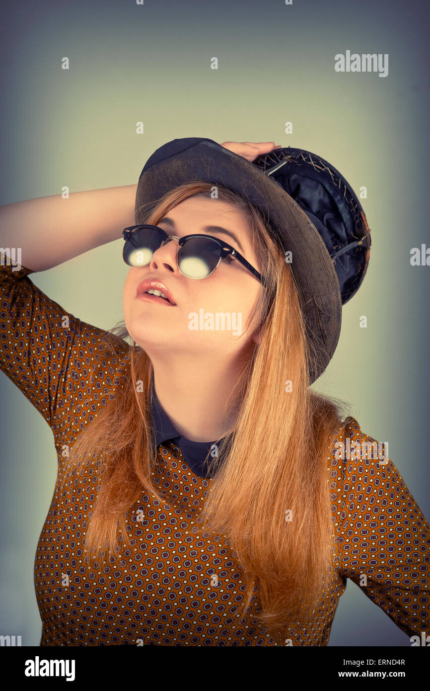 Tramp girl wears old top hat in vintage photo style Stock Photo