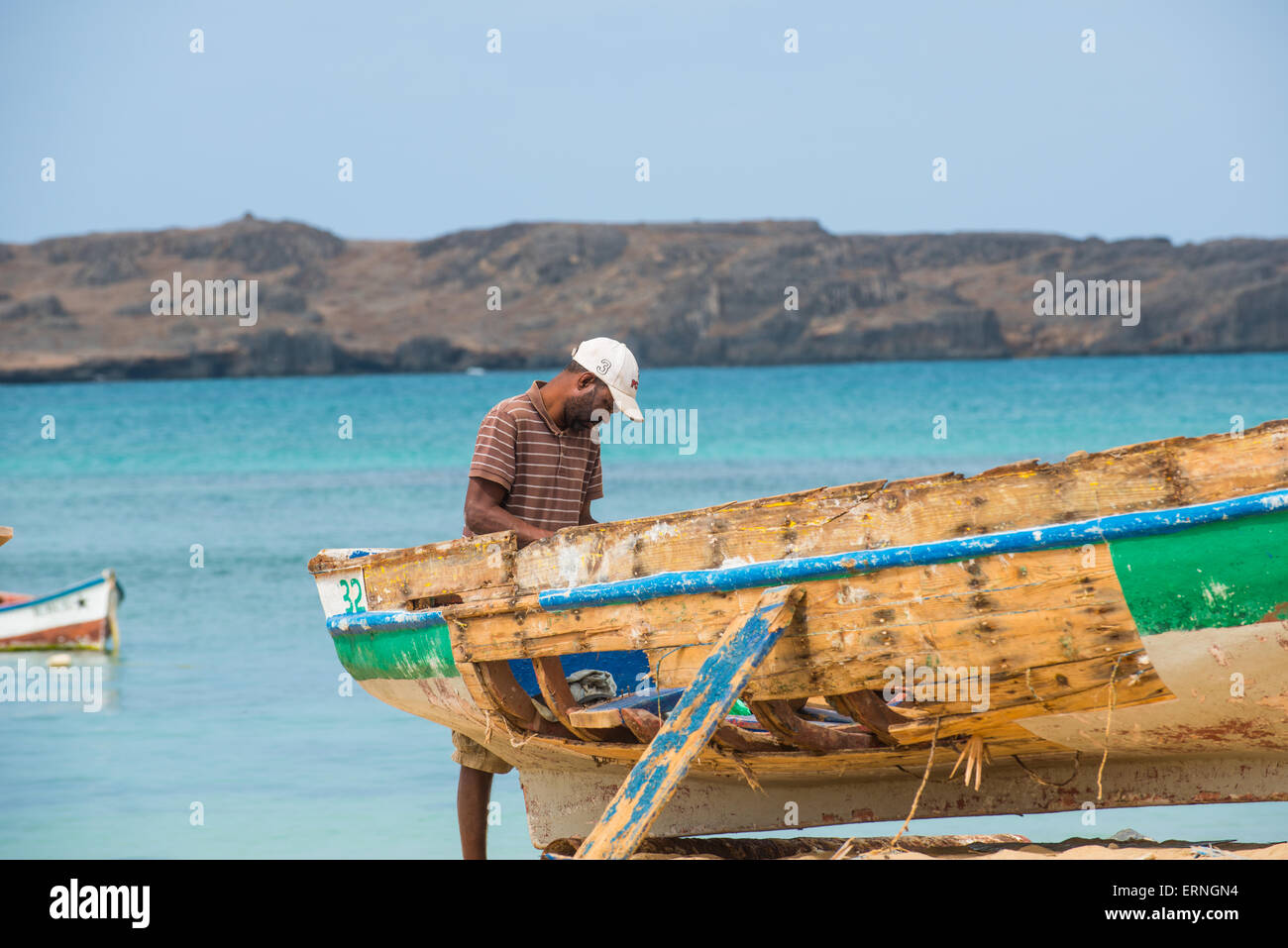Local resident of Boa Vista working at his boat on the beach Stock Photo