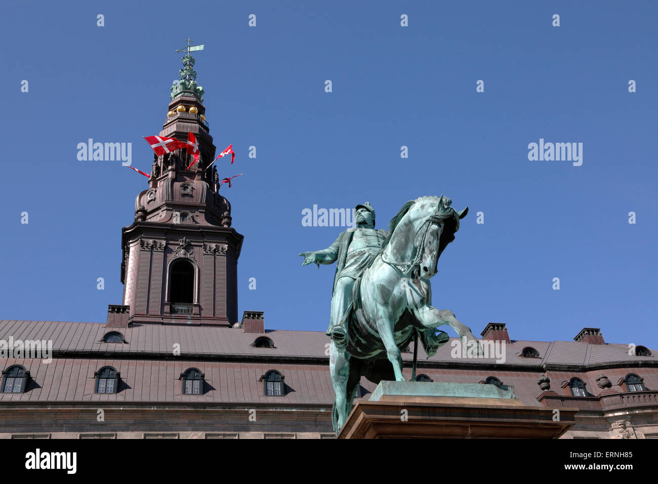 Copenhagen, Denmark, 5th June, 2015. The amendment of the Danish Constitution in 1915 gave Danish women the right to vote and stand for election. This important anniversary is celebrated in Copenhagen on the Constitution Day by the Government, the Parliament and the ongoing Distortion Festival in Copenhagen. The events are concentrated around the Christiansborg Palace. The equestrian statue of King Frederik 7th in front of Christiansborg presenting the Danish flags in the tower turrets. Credit:  Niels Quist/Alamy Live News Stock Photo