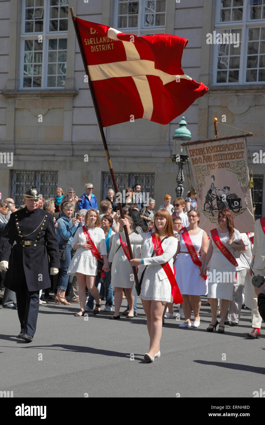 Copenhagen, Denmark, 5th June, 2015. The commemorative parade on Constitution Day in celebration of the 100th anniversary of the Constitution amendment in 1915 that gave the women the right to vote and stand for election, arrives to the finish point in the Christiansborg Palace yard. The entry is lead by members of Dansk Kvindesamfund (Danish Women’s Society), flag and red sashes, followed by participants in historic garments from early 20th century, and thousands of others finding it important to commemorate the anniversary. Credit:  Niels Quist/Alamy Live News Stock Photo