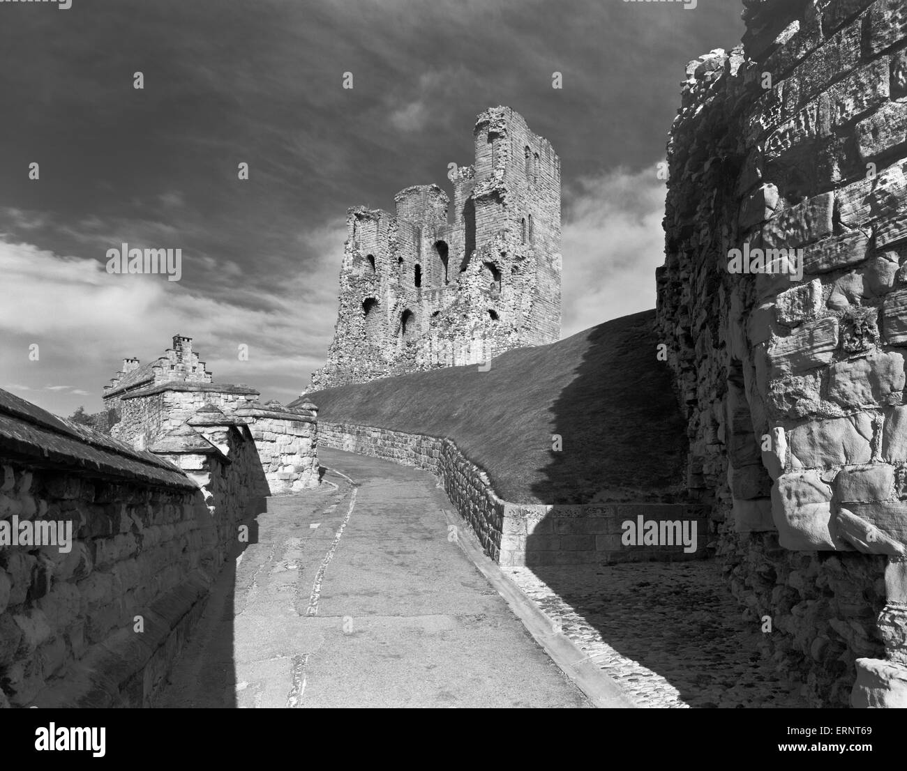C12th stone keep of Henry II at Scarborough Castle, North Yorkshire, seen through later defences: walkway, curtain wall, bridge & barbican. Stock Photo