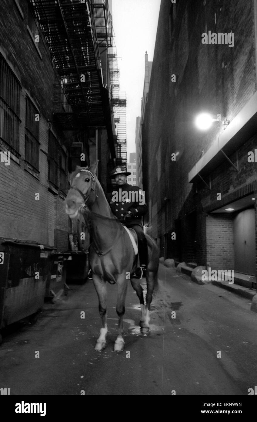 Chicago, IL, 14-Dec-1996: A mounted policeman is looking down from the back of his horse in a dark side street of Madison Ave / Wabash. Stock Photo