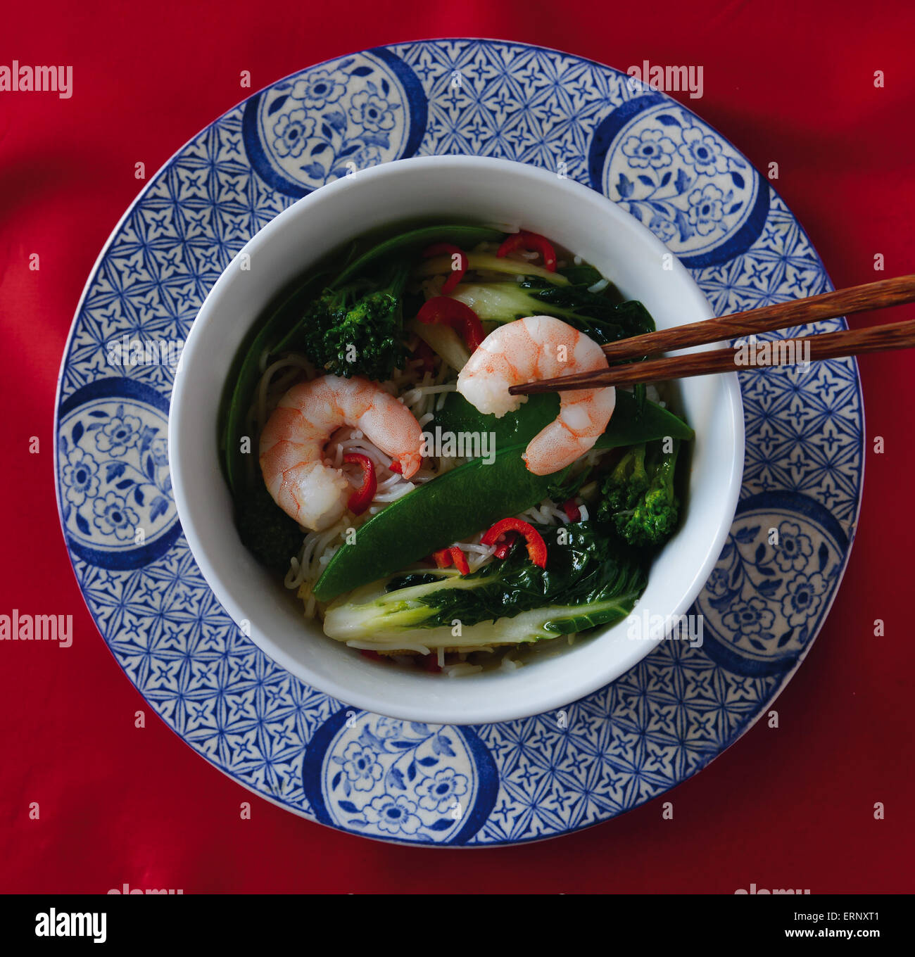 Stir fry shrimps (prawns) with rice noodles on decorative Chinese plate with chopsticks Stock Photo