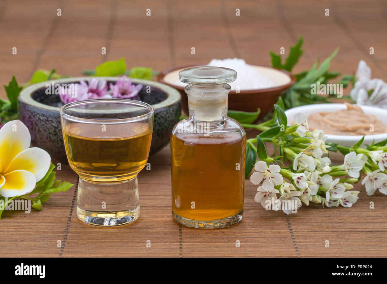 Essential Oil, flower float on water, salt bowel and mask for health spa Stock Photo