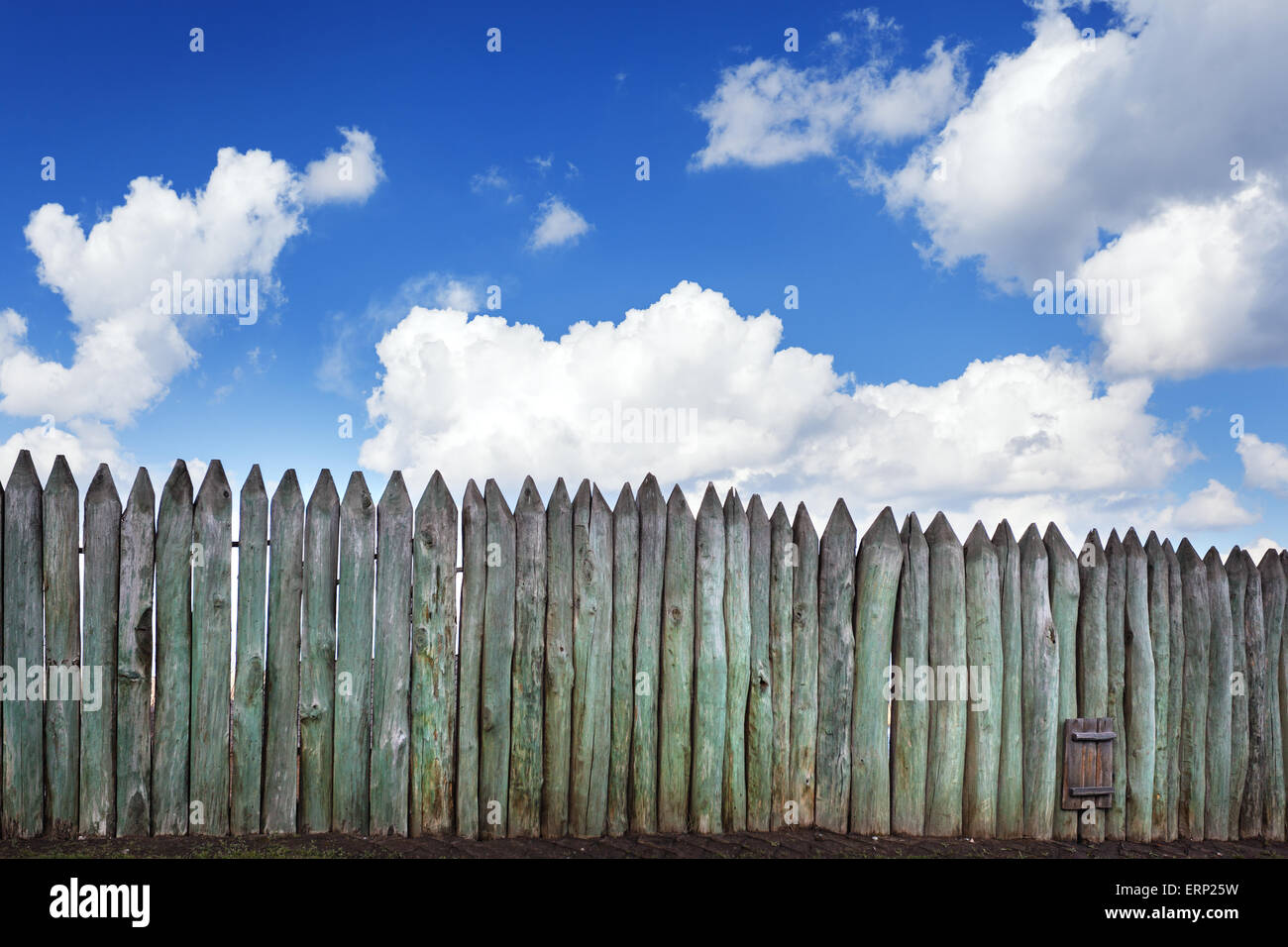 Old wooden fence against blue sky with clouds. Background for design Stock Photo