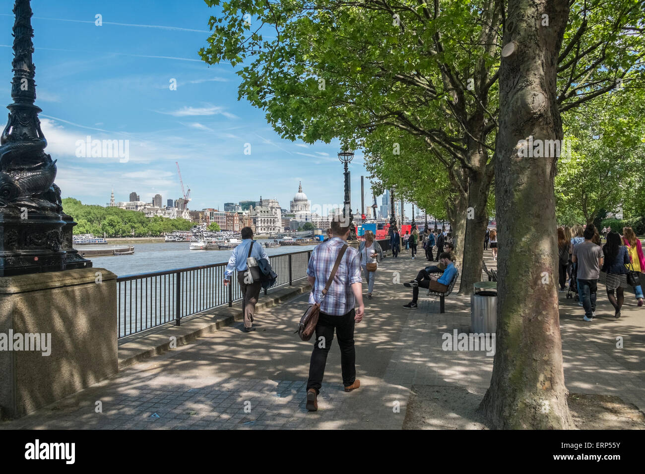 People walking along Thames Pathway, Southbank, with St Pauls Cathedral in the city skyline, London UK Stock Photo