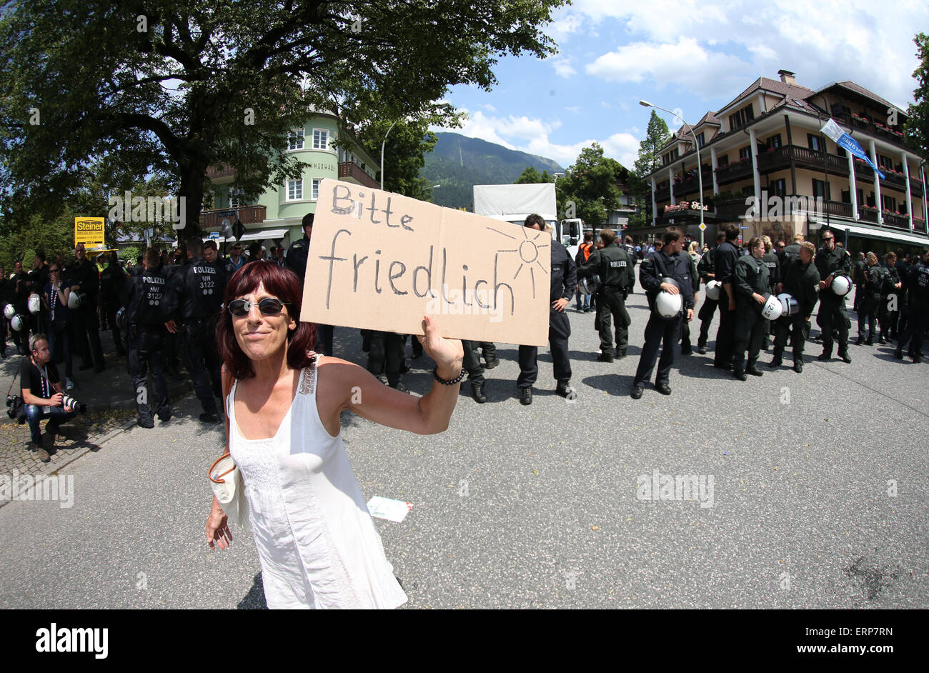 Garmisch-Partenkirchen, Germany. 06th June, 2015. A woman holds a sign reading 'Bitte friedlich' (lit. Peacefully please) in Garmisch-Partenkirchen, Germany, 06 June 2015. Heads of state and government of the seven leading industrialized nations (G7) are scheduled to meet in Elmau Castle, Bavaria, on June 7-8 as the climax of Germany's presidency of the G7. Photo: CHRISTIAN CHARISIUS/dpa/Alamy Live News Stock Photo