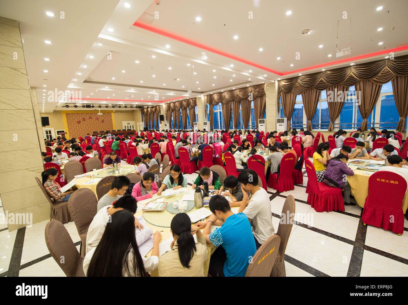 (150606) -- CHONGQING, June 6, 2015 (Xinhua) -- Students prepare for the coming national college entrance exams at the hall of a hotel in Bishan District of Chongqing, southwest China, June 6, 2015, one day before the exams.  About 1300 students of Laifeng High School would attend the exam in Bishan District, a site 20 kilometers away from their school, on June 7 and 8, therefore, most of the students booked hotels near the exam site and prepared for the exam at the last night. (Xinhua/Liu Chan) (zkr) Stock Photo