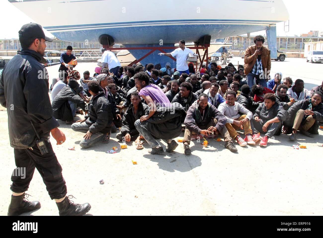 Tripoli, Libya. 06th June, 2015. A batch of illegal immigrants sit on the ground after being detained by Libyan coast guard near Garabulli, Libya on June 6, 2015. The Libyan coast guard intercepted dozens of sub-Saharan nationals trying to stow away to Europe from Libyan coast. Credit:  Xinhua/Alamy Live News Stock Photo