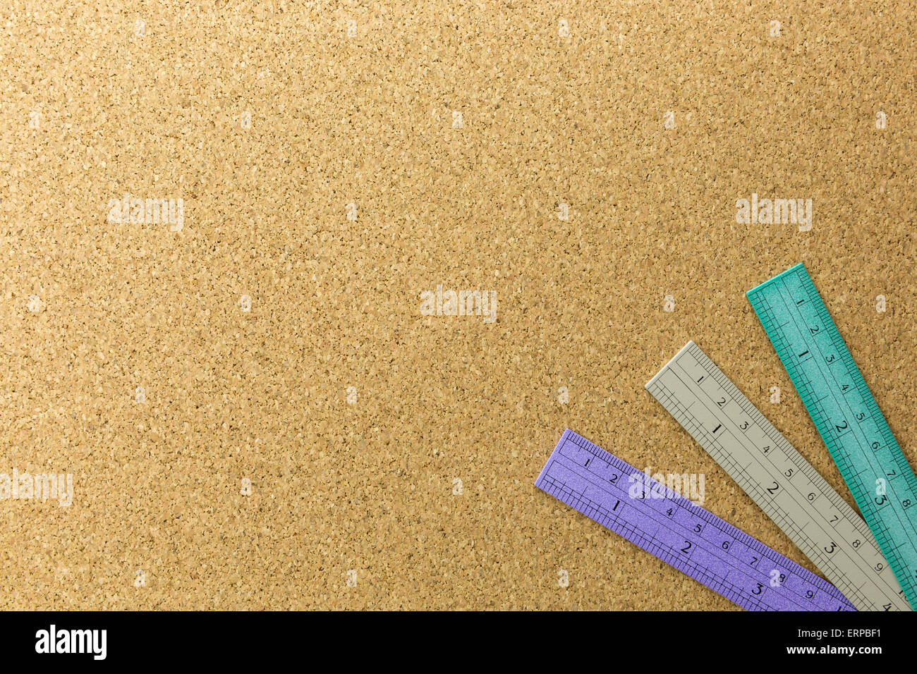 three color of rulers place on cork board at the corner Stock Photo