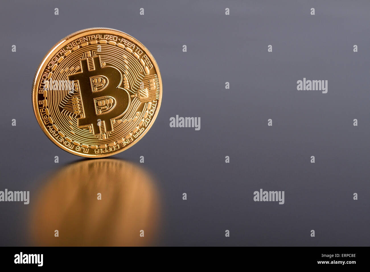 Studio shot of golden Bitcoin virtual currency on gray. Close-up of front side. Stock Photo