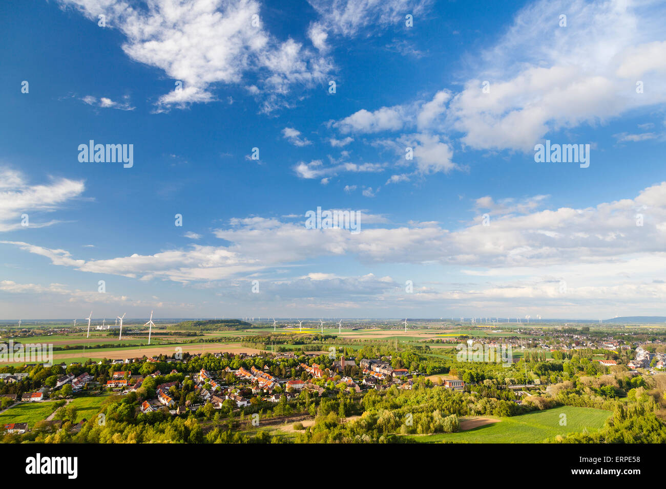 Flat west German landscape near Aachen and Herzogenrath with lots of wind turbines and some clouds on blue sky. Stock Photo