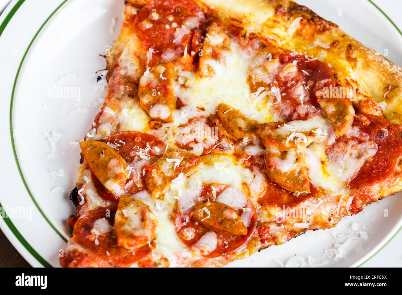 Fresh pepperoni and sausage pizza slice on the table in Italian