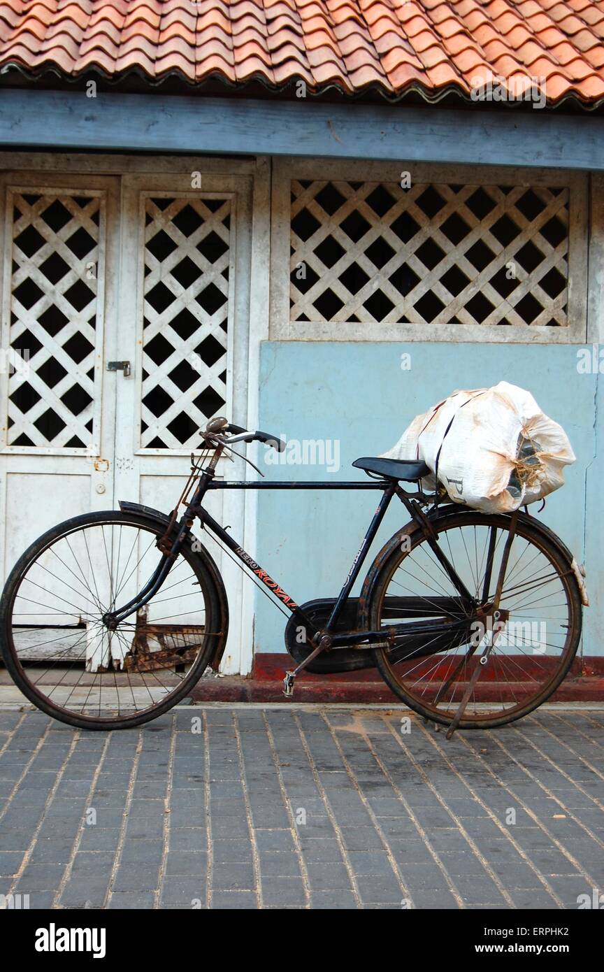 An old bicycle against a colonial building on the street in Galle ... - An OlD Bicycle Against A Colonial BuilDing On The Street In Galle ERPHK2