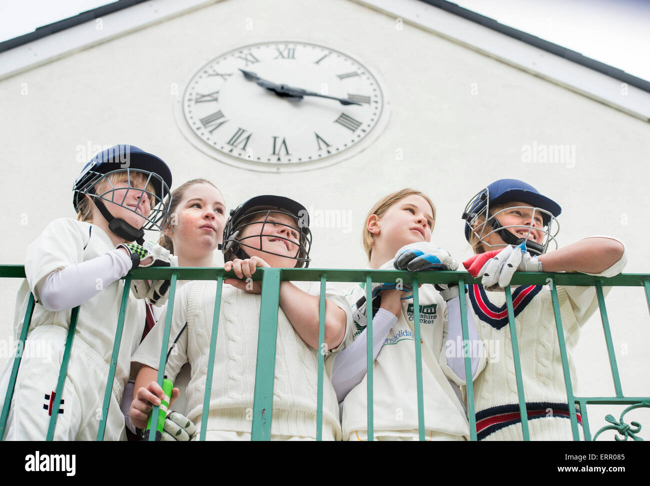 Girls watch their teams batting performance from the pavilion balcony at a junior girls cricket match in Wiltshire UK Stock Photo