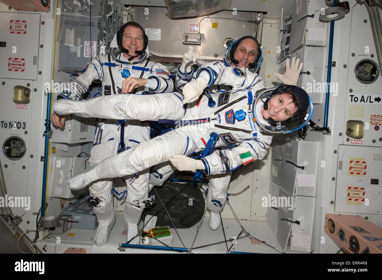 International Space Station Expedition 42 Flight Engineer Samantha Cristoforetti of the European Space Agency floats around fellow NASA astronaut Terry Virts (left) and Russian cosmonaut Anton Shkaplerov as they perform a checkout of their Russian Soyuz spacesuits in preparation for the journey back to Earth May 6, 2015 in Earth Orbit. Stock Photo
