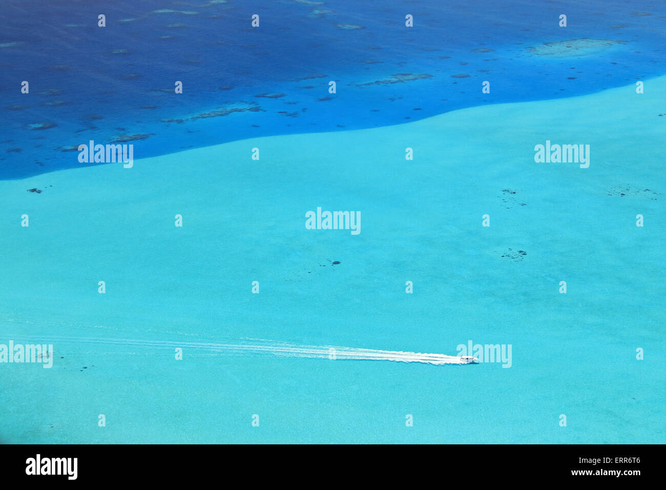 Flight View of a Motor Boat Crossing a Coral Reef, Maldives Stock Photo