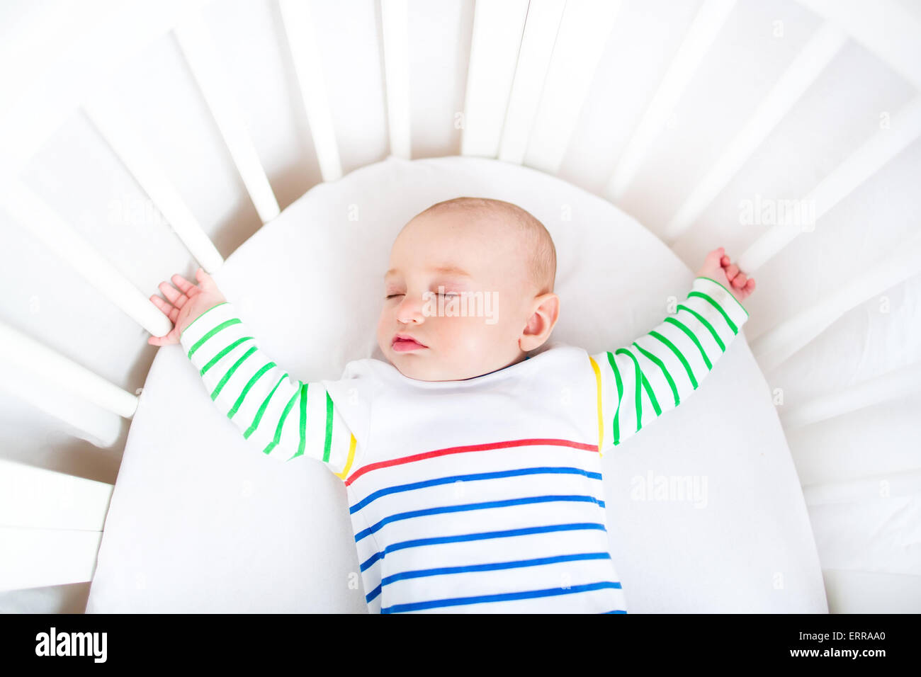 Cute newborn little boy sleeping in a white round crib Stock Photo