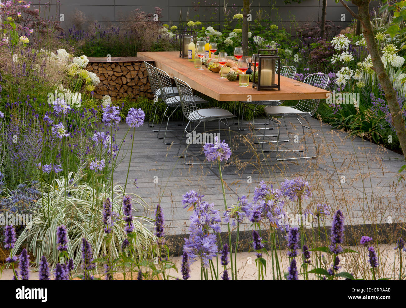Lavandula and agapanthus next to a dining area in The Vestra Wealth Vista Garden at the Hampton Court Flower Show Stock Photo
