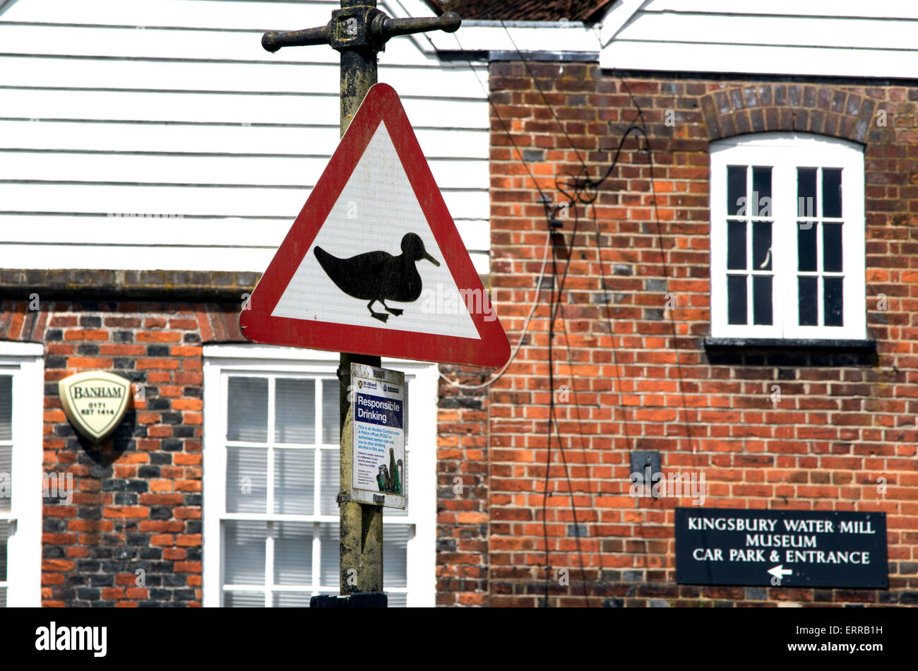 Duck ducks crossing road sign near river beware Stock Photo