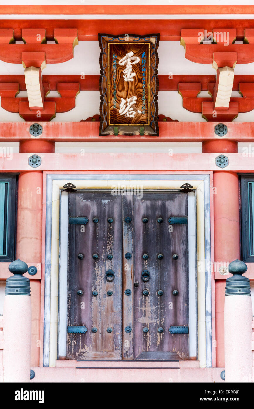 Old weathered wooden double doors, with surrounding ornate framework and name board above door, entrance to the pagoda at Chion-in temple in Kyoto. Stock Photo