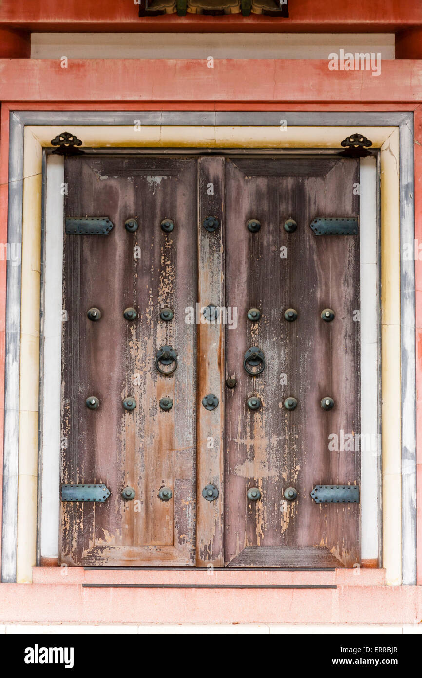 Old weathered wooden double doors, entrance to the pagoda at Chion-in temple in Kyoto. Manju Kanamono, round shaped nail coverings, chichi kanamono. Stock Photo