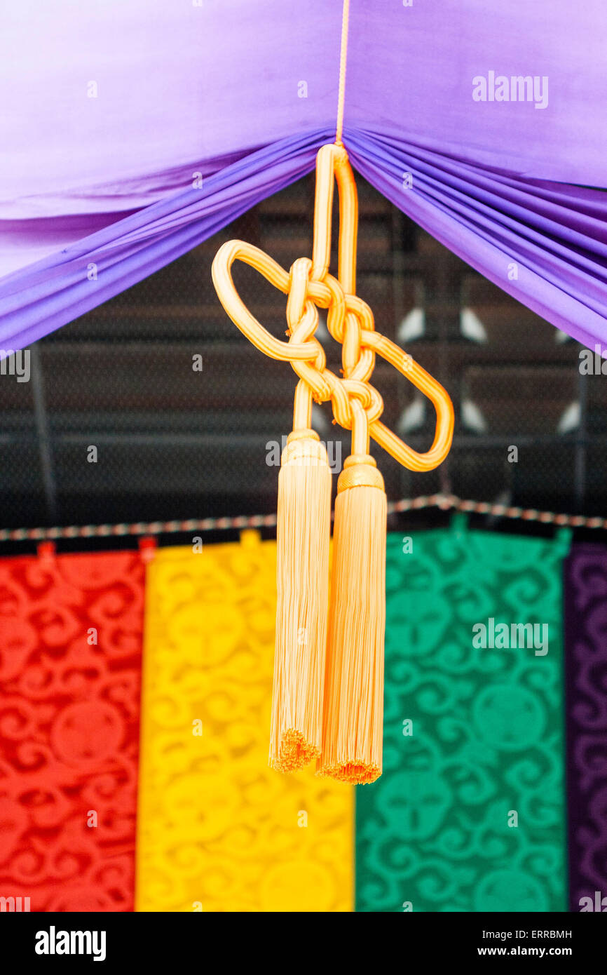 Chion-in temple, Kyoto, Japan. Braided knotted rope, called hanamusubi,  hanging from the Buddhist temple roof with background of coloured curtains  Stock Photo - Alamy