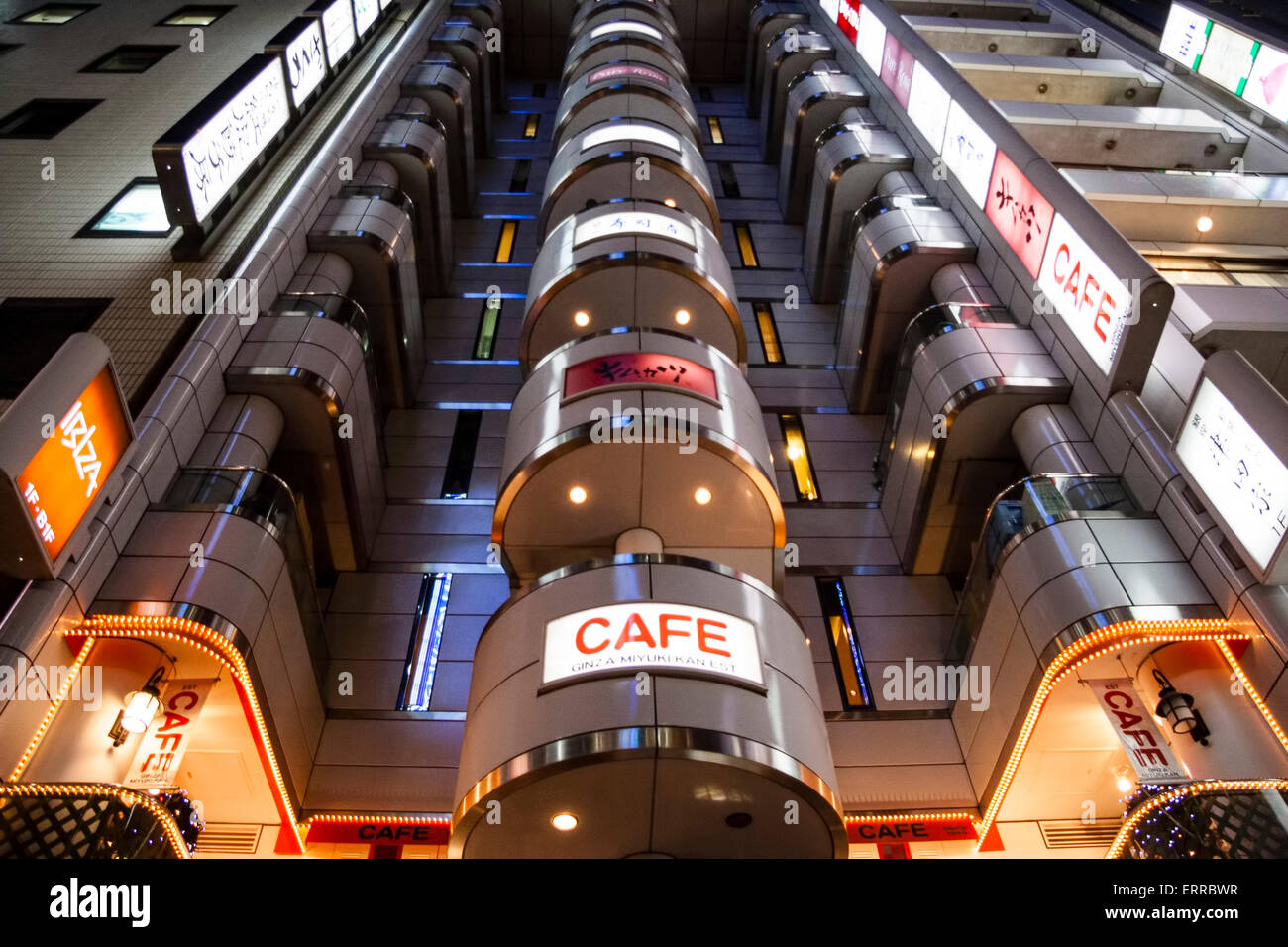 The Cafe de Ginza Miyuki-kan in the distinctive W facade shape of the Ginza Act Building in Tokyo at night. Low angle view looking up the building. Stock Photo
