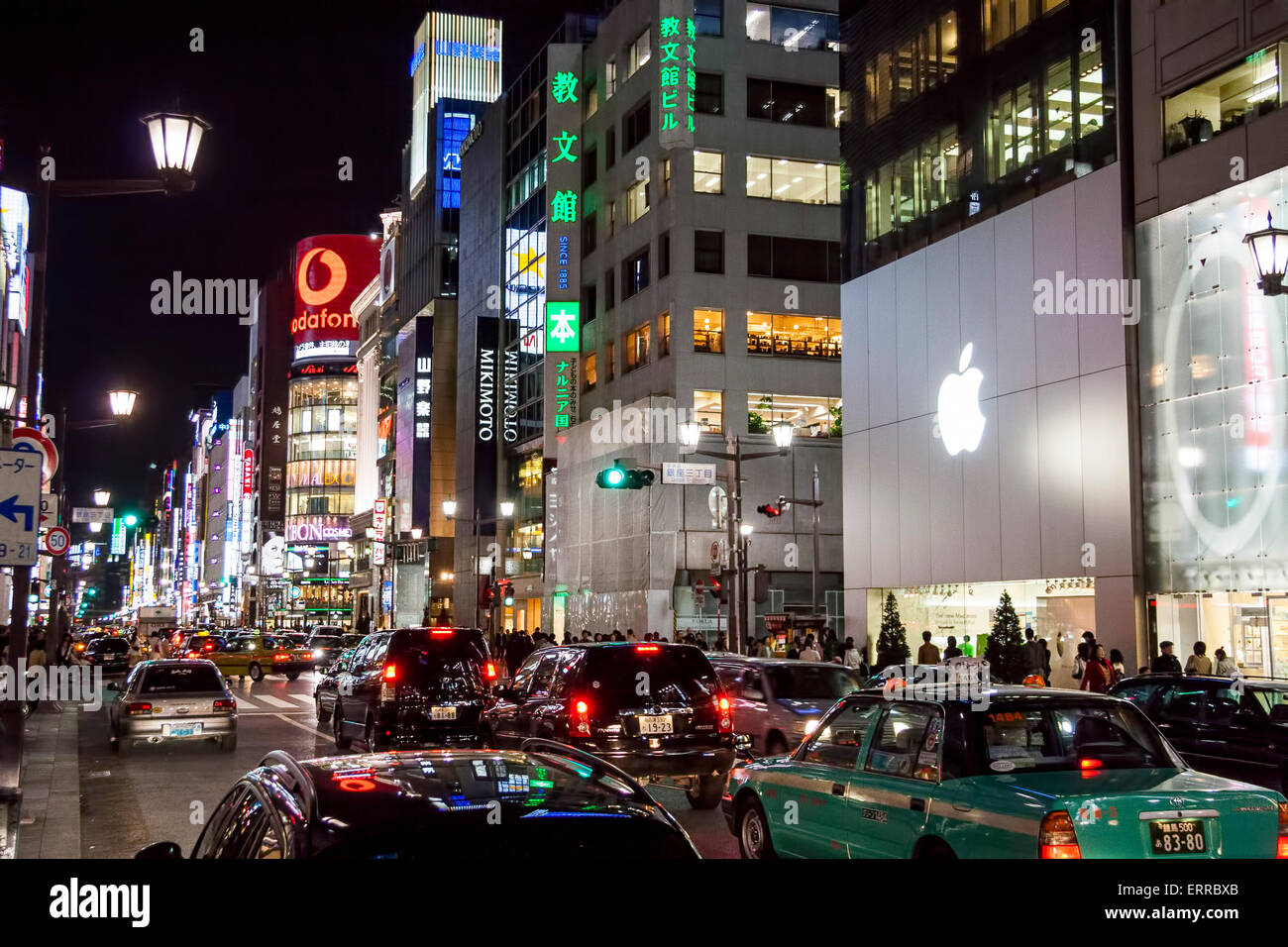 The Ginza at night. View along traffic filled street with the Apple ...