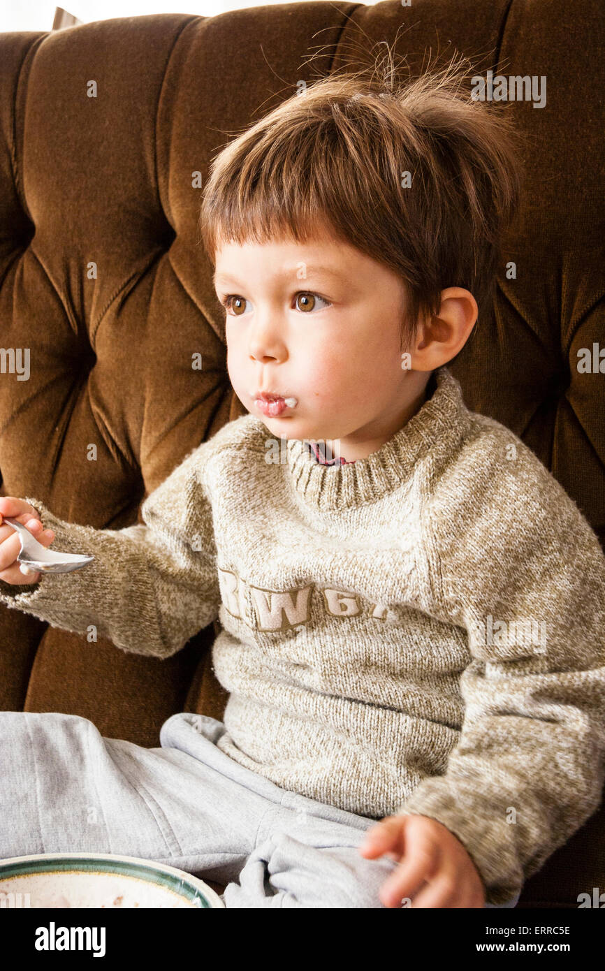 3 To 5 Year Old Caucasian Child Boy Sitting On Sofa Eating