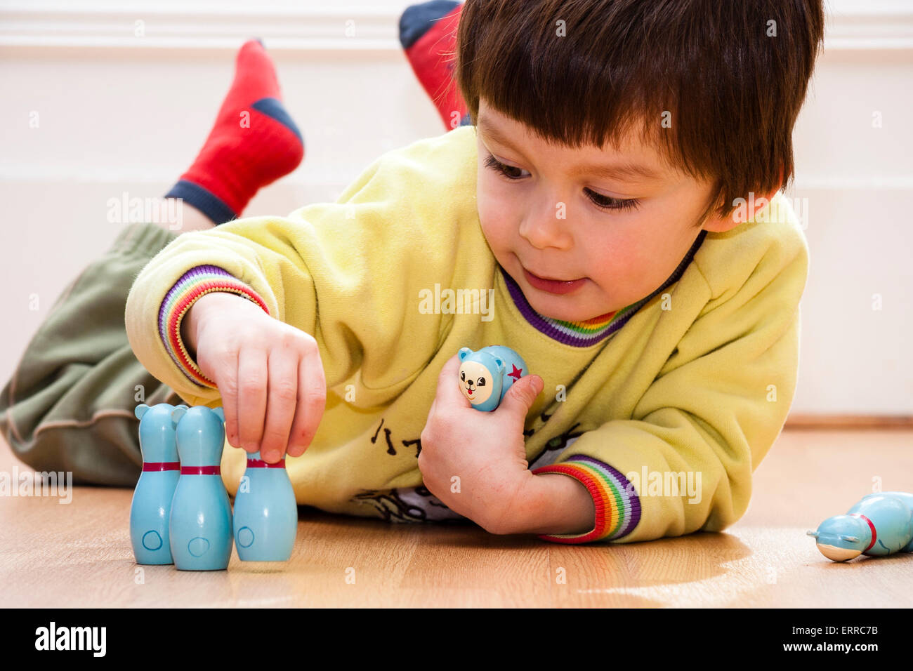 Caucasian child, boy, 45 year old, laying on floor playing with a set