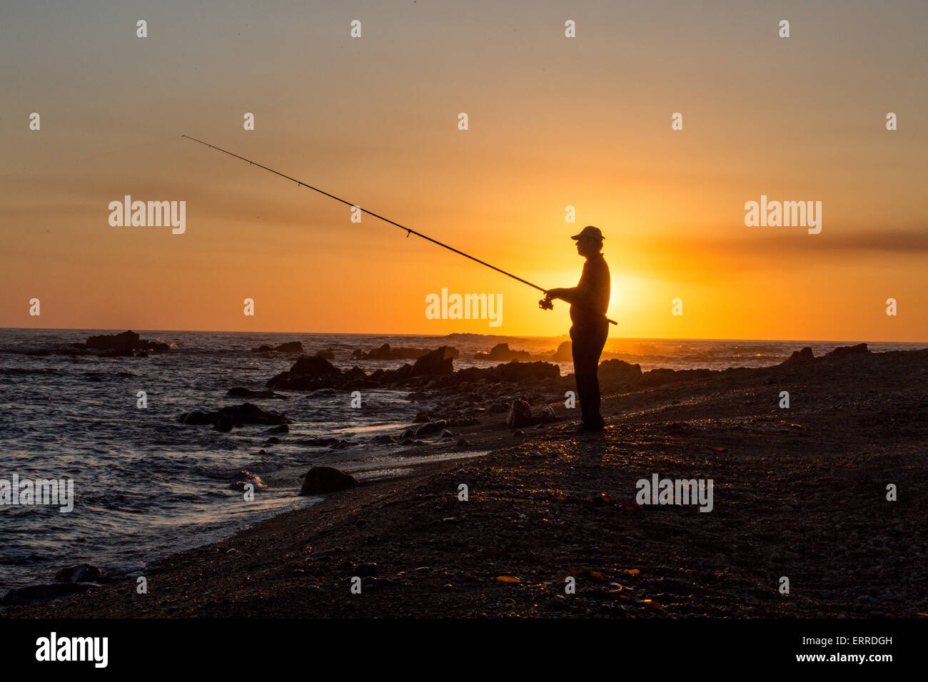 silhouette of fisherman fishing on coast Stock Photo - Alamy