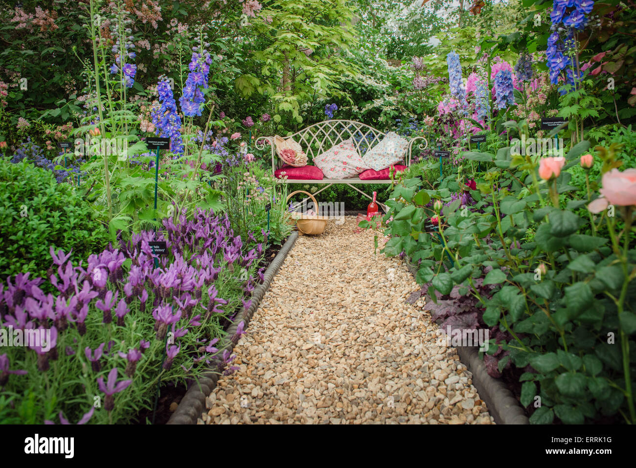 Chelsea Flower Show 2015, bench in the garden surrounded by flowers with gravel path Stock Photo