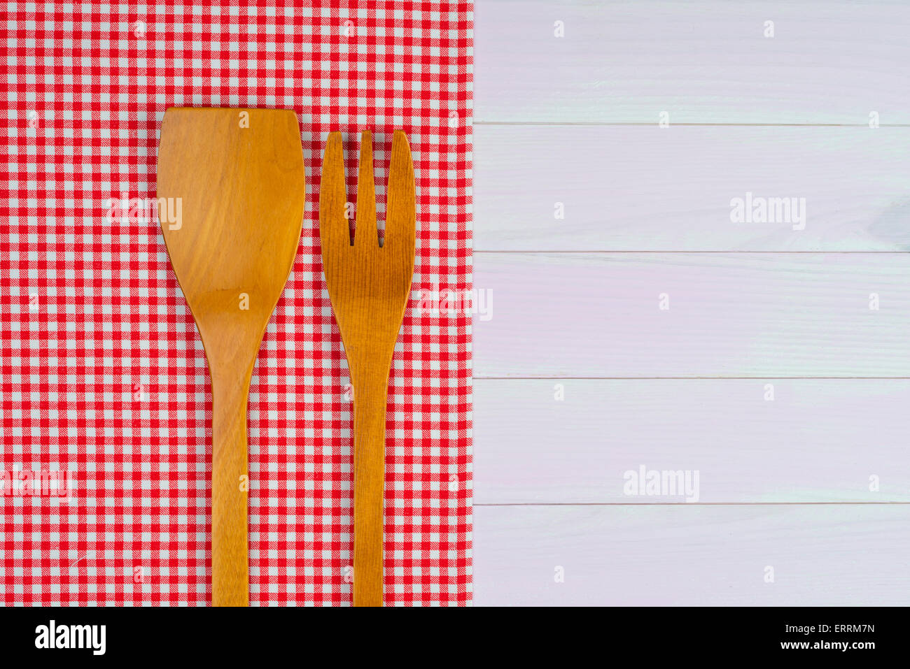 Kitchenware on white and red towel over wooden kitchen table. View from ...