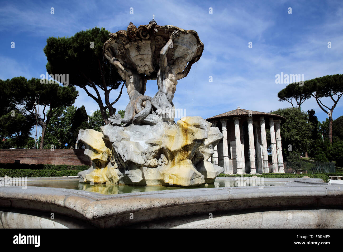 Fountain with Tempio di Ercole Vincitore in the background are part of Forum Boarium in Rome Italy Stock Photo