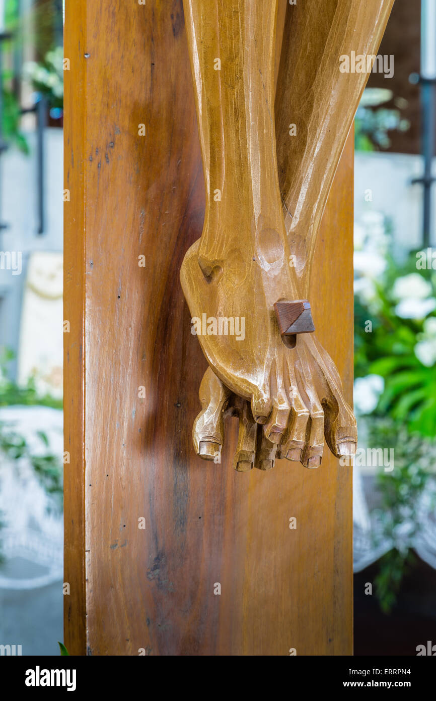 the detail of nailed feet in a wood carved statue of the Crucifixion of