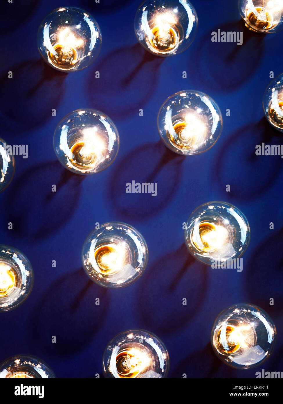 A group of illuminated incandescent light bulbs shining on blue