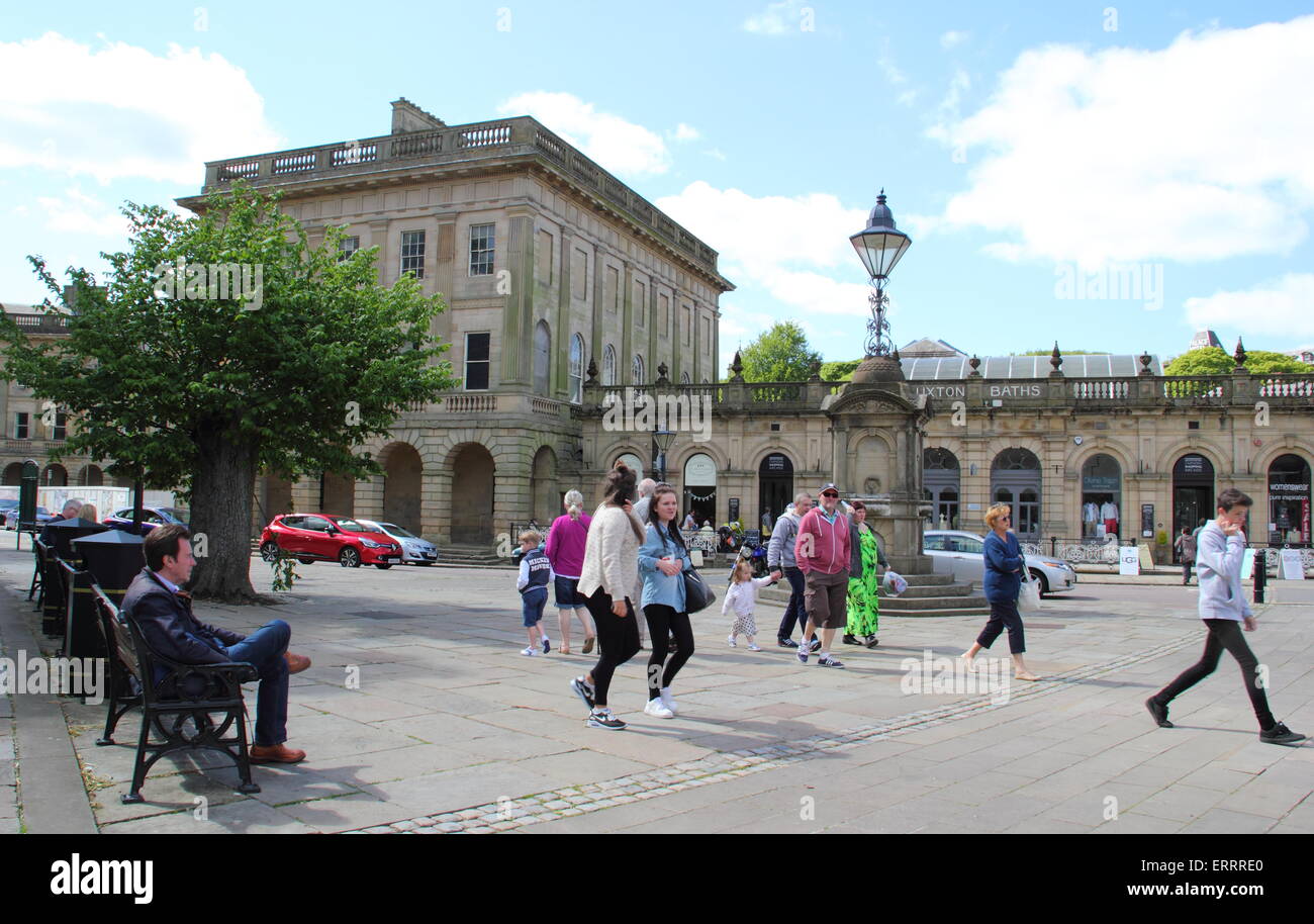 People pass by the Thermal Baths and Cavendish Arcade on The Crescent in Buxton, Derbyshire on a warm, sunny day, England UK Stock Photo