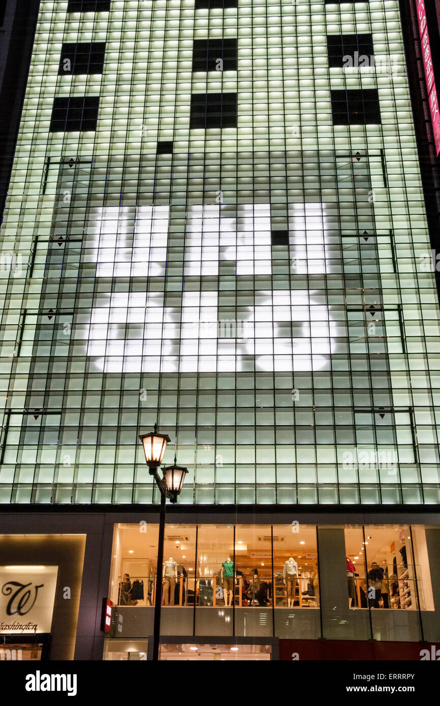 The Ginza in Tokyo. The Flagship, 12 story, Uni Qlo clothing department store during evening with the facade illuminated the uni Qlo brand name. Stock Photo